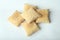 Top view closeup shot of a pile of square puff biscuits on a white surface