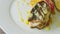 Top view closeup trendy decorated grilled sea fish on sliced peppers rotates on plate