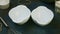 Top view closeup on two small empty white bowls stand on dark kitchen table