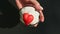 Top view closeup woman hand shows chocolate cupcake with heart shaped candy