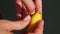 Top view closeup woman hands put yellow lemon shaped candy into brown stand