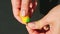 Top view closeup woman hands stick in dried clove into pear shaped marzipan candy