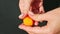 Top view closeup woman hands take small round piece of orange marzipan mass