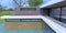 Top view of the cobbled courtyard of a house built in a minimalist style. The spacious terrace is fenced with glass. Large