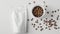 Top view of coffee beans in white cup with craft white mockup bag for elegant presentation