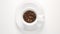 TOP VIEW: Coffee beans in a white cup stop motion