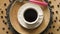 Top view of coffee with spoon on decorative plate on wooden table