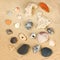Top view of collection of beach stones rock and shells over sand