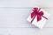 Top view color gift box with ribbon on white wooden plank