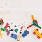 Top view on color plastic toys and bricks on old white wooden background. Early learning and development