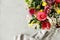 Top view of a colorful bouquet of beautiful flowers in the corner and gray blurry background with a piece of fabric