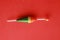 Top view of a colorful fishing rod bobber on a red background