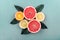 Top view of colorful fruit slices with citrus leaf arrangement. Summer tropical juice concept with lemon, grapefruit and orange on