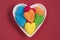 Top view of colorful jelly candy sweets in heart shaped plate isolated on red