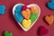 Top view of colorful jelly candy sweets in heart shaped plate isolated on red