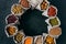 Top view of colorful nutritious cereals and dried fruit in small sacks standing in circle,  over dark background. Food