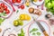 Top view of Colorful sliced tomatoes on white kitchen table with knife and enamelware