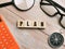 Top view compass,eye glasses,calculator and magnifying glass with text PLAN written on wooden cubes.