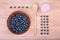 A top view of a composition of blueberries on a wooden background. A spoon and a glass of berry smoothie. Blueberries in a basket.