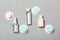 Top view composition of small travelling bottles and jars for cosmetic products on gray background. Facial skin care concept with