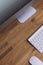 Top view of a computer monitor with a blank screen on a pure white background of a brick wall and a keyboard and mouse on a wooden