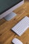 Top view of a computer monitor with a blank screen on a pure white background of a brick wall and a keyboard and mouse on a wooden