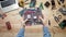 Top view computer technician holding computer motherboard at wooden desk with tools and electronic components