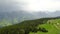 Top view of coniferous forests in mountain valleys in cloudy weather. Action. Picturesque panorama of green forest