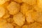 Top view corrugated golden chips background, grooved pattern and texture of fast food for copy space