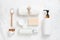 Top view of Cosmetic bottles, soap, wooden spoon and towel on white marble.
