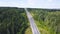 Top view of countryside highway in forest area. Clip. Rural road with traffic of cars and trucks going to city on