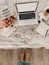 Top view of cozy blogger workplace with mockup laptop, agenda, coffee cup and decorations on bed