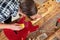 Top view of craftsman sanding a guitar neck in wood at workshop