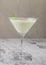 Top view cream milk cocktail with mint on a gray background. An irish cream liquor in a martini glass. Bar alcohol drink