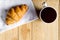 Top view croissant on white fabric and coffee on wooden table with copy space