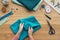 top view of cropped female hands folding fabric at seamstress workplace with scissors