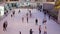 top view of crowd of young men and women, children enjoying the skating on indoor ice rink. Indoor ice rink in the mall