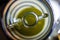 Top view of a cruet full of green extra virgin olive oil