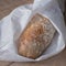 Top view of crusty home made ciabatta sour dough bread loaf wrapped in tissue paper, baked during the Coronavirus lockdown.
