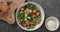 Top view cucumber over kale leaves in white ceramic bowl on concrete background