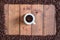 Top view cup of coffee with coffee beans square frame on wooden