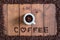 Top view cup of coffee with coffee beans square frame on wooden