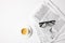 top view of cup of coffee and eyeglasses on newspapers, on white table