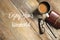 Top view of a cup of coffee,glasses,pen and notebook on wooden background written with Enjoy Your Weekend.