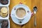 Top view of a cup of coffee at the kitchen table cookies and spoon.