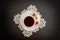 Top view of a cup of coffee and Turkish delight with almonds on a saucer, lace doily