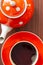 Top view of cup with hot aromatic black tea and teapot with white polka dots on a wooden table. Tea time concept. Flat lay