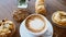 Top View Cup of Hot Coffee Cappuccino on Wooden Table with Bakery Pastry Items