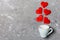 Top view of a cup and red hearts falling out from it on cement background. Happy Valentine`s Day concept