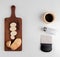 top view of cut and sliced potato on cutting board with salt black pepper and potato chip cutter on white background